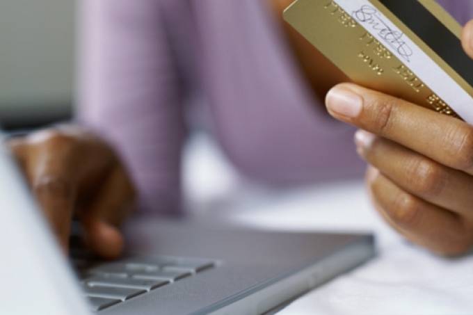 Imagem do artigo da Veja com uma pessoa efetuando compra pela Internet